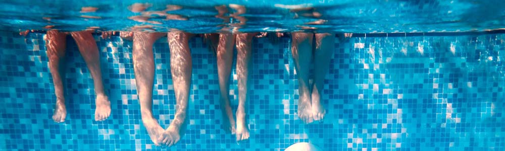 Kids legs kicking underwater in a pool