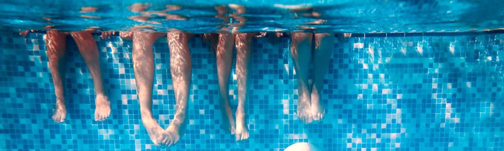 Kids legs kicking underwater in a pool
