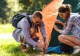 A young man and woman setting up a tent while camping