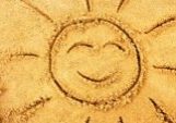 Drawing of the sun in beach sand with flip flops
